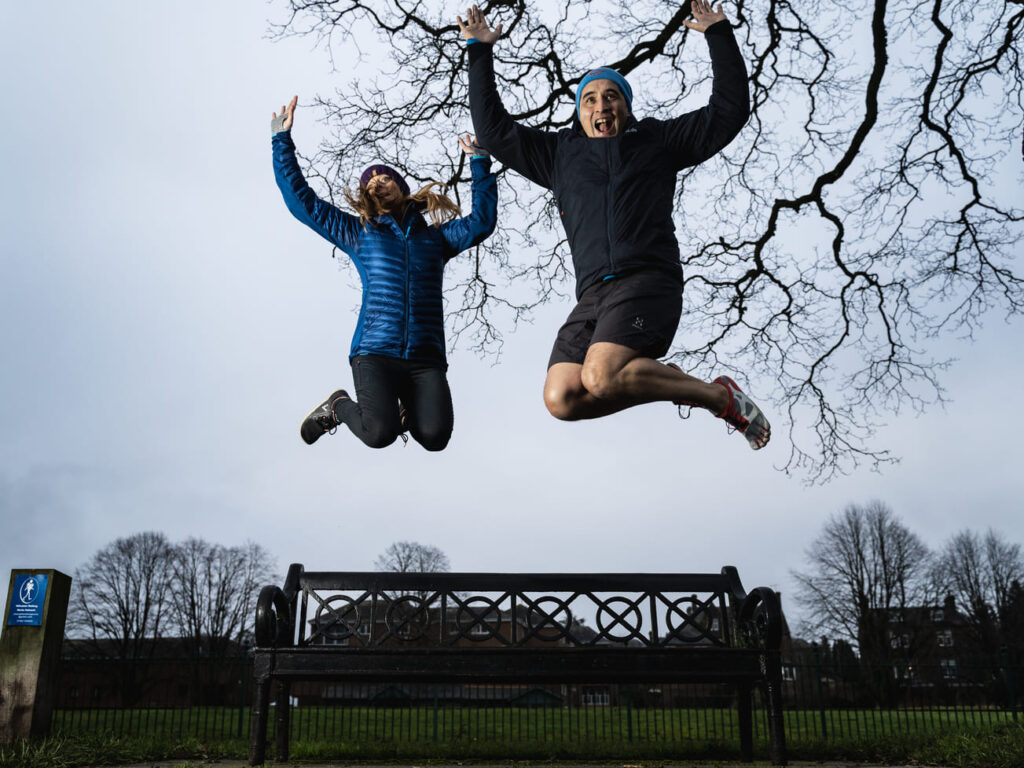 Phil Young & Julie Tod jumping on a park bench